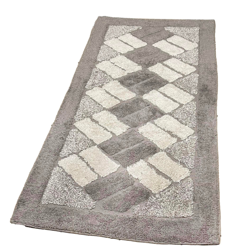 Kilimas „Beige Diamond Mosaic Rug“, 70x140 cm. Smėlinis kilimas su kreminės spalvos stačiakampiais ir tamsesnių smėlinės trikampių akcentais kampuose. Kilimas „Beige Diamond Mosaic Rug“, 70x140 cm. Smėlinis kilimas su kreminės spalvos stačiakampiais ir tamsesnių smėlinės trikampių akcentais kampuose.
