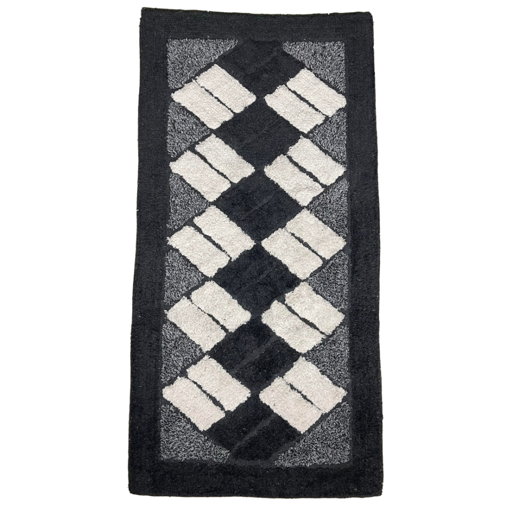 Kilimas „Black Diamond Mosaic Rug“, 70x140 cm. Stačiakampio formos juodas kilimas su kreminėmis stačiakampėmis figūromis, išdėstytomis įstrižai rombų motyvais. Kilimas „Black Diamond Mosaic Rug“, 70x140 cm. Stačiakampio formos juodas kilimas su kreminėmis stačiakampėmis figūromis, išdėstytomis įstrižai rombų motyvais.