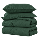 Lininė patalynė „Linen Dark Green“. Patalynės komplektai 150x200, 140x200 cm, 150x200 cm, 160x200 cm, 180x200 cm, 200x200 cm, 200x220 cm, 220x240 cm. Lova užklota tamsiai žalia lino patalyne su dviem pagalvėmis šviesiame interjere.